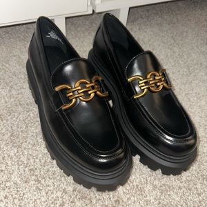 Black platform loafers with gold detail